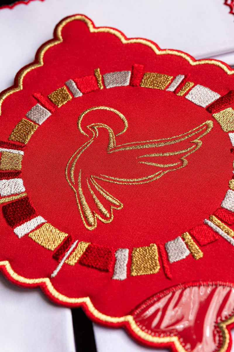 Juego de paños rojo con un bordado del Espíritu Santo
